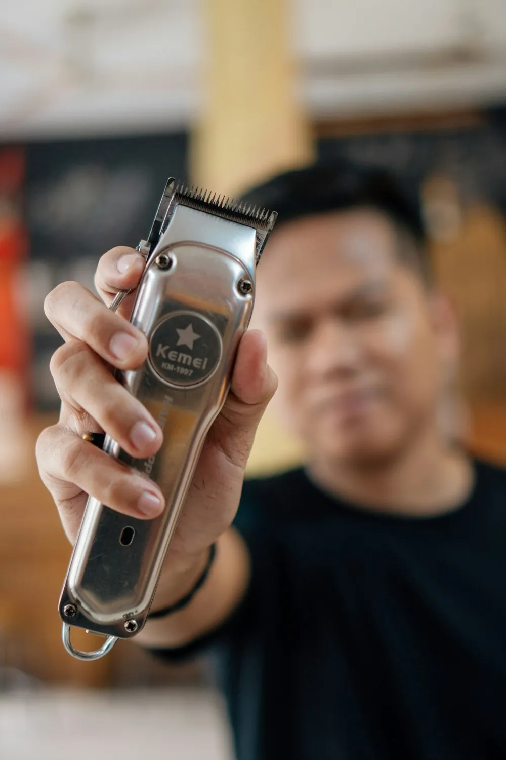 Barber holding clippers, close up